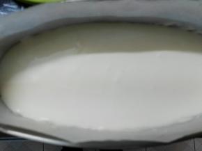 取出活底模具铺上油纸四周也铺上把之前做的海绵蛋糕切片放在最底下然后把芝士糊倒入在海棉蛋糕上面，我这里是用的学厨芝士蛋糕模