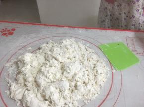 白色面团搅拌成絮状，然后用掌根搓揉面粉使其成团
