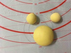 现在用黄色面团来制作一个小熊维尼哦，将黄色面团分成一个40克，2个10克，分别揉圆制作小熊维尼的头部，耳朵。