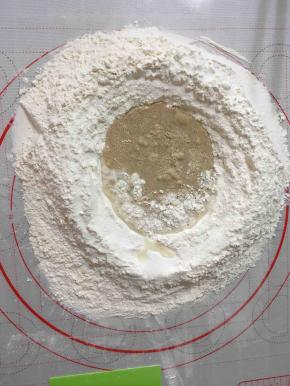 白色面团，面粉开窝先后加入、酵母、水拌成絮状