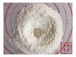 手工和面，准备黄色面团，面粉开窝放入酵母
