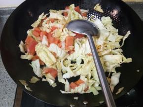 热油锅，倒入菜菜，先不要翻炒，因为西红柿在下面，等西红柿被油烫十几秒出点汤汁再翻炒