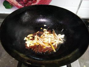 下入葱丝、蒜片、烹入料酒炒出香味