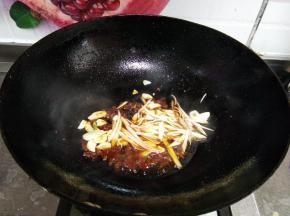 下入葱丝、蒜片、烹入料酒炒出香味