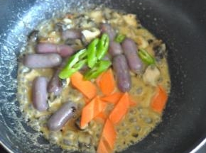 将年糕煮软后，加入胡萝卜和尖椒。