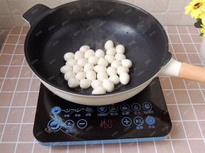 不粘锅中倒入适量花生油，烧热后放入鹌鹑蛋