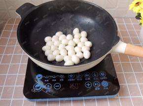 不粘锅中倒入适量花生油，烧热后放入鹌鹑蛋