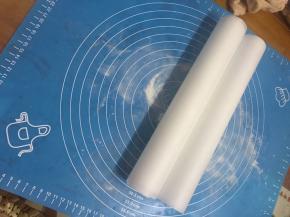 准备两张油纸，抹上中筋粉防粘