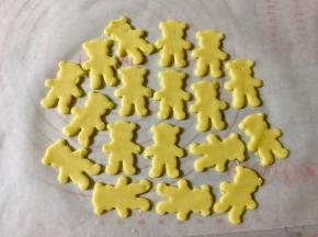 然后把小熊周围的边角料揭下来，这些剩余的面团还可以重新擀成面皮，做更多饼干。