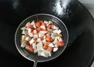 然后把香芋丁和胡萝卜丁捞起控干油；