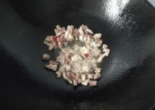 锅中留底油，先放入腊肉丁翻炒一下；