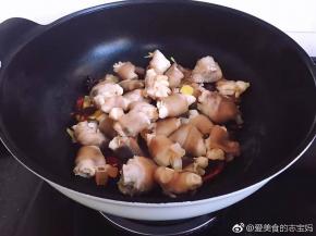 接着开大火倒入羊蹄翻炒片刻，淋上少许花雕酒。