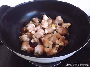 接着开大火倒入羊蹄翻炒片刻，淋上少许花雕酒。