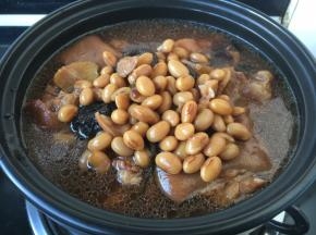 将步骤18一部分的猪手黄豆连同汤汁放入砂锅里。