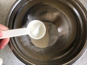 【制作糖霜】蛋白粉倒入容器内，加入最大的那个量勺（即15cc）的，加入两勺清水