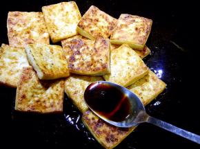 另用锅放少许油加热，放入煎好的豆腐片，放入生抽