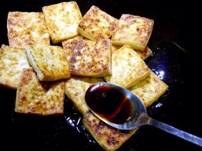 另用锅放少许油加热，放入煎好的豆腐片，放入生抽