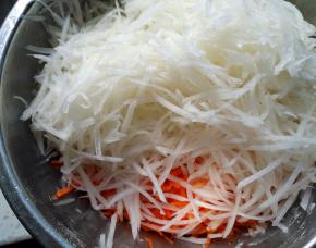 将两种萝卜擦丝，加入食盐