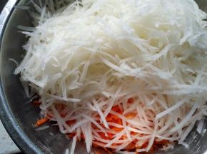 将两种萝卜擦丝，加入食盐