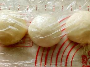 轻轻取出面团不要用力撕扯面团，用刮板平均切分成3份，如有大气泡用手轻拍两下即可，滚圆盖保鲜松弛20分钟。