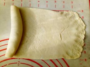 每个面团用擀面杖擀成牛舌形卷起来，盖保鲜膜松弛20分钟。