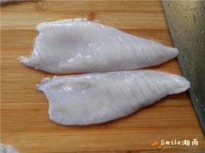 把鱿鱼无皮的那面朝上，在鱿鱼身上轻轻的斜着切出间隔为3毫米宽的条，不要把鱿鱼切断。