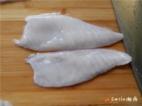 把鱿鱼无皮的那面朝上，在鱿鱼身上轻轻的斜着切出间隔为3毫米宽的条，不要把鱿鱼切断。