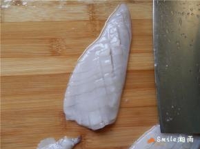 全部切好后，将鱿鱼转个方向，用倾斜45度的刀，切间隔为3毫米宽的条，勿切断鱼身。