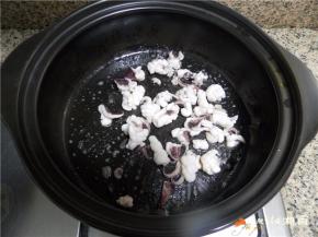 黑乐砂锅洗干净擦干水分，放灶上加热，放油烧至六七成热，滑入鱿鱼卷过油，捞出控油