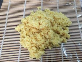 寿司垫上铺一张保鲜膜，勺入米饭