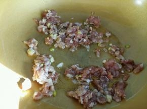 腌制好的肉沫倒入油中翻炒。