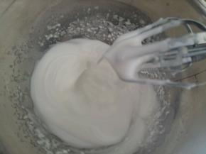 蛋白打发至出现弯弯的尖角后加入剩余的白糖。然后打发至硬性发泡。