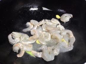 炒锅倒入适量食用油，然后放入虾仁翻炒，待颜色变红之后盛出备用
