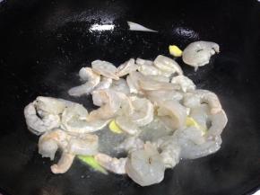 炒锅倒入适量食用油，然后放入虾仁翻炒，待颜色变红之后盛出备用