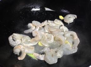 炒锅倒入适量食用油，然后放入虾仁翻炒，待颜色变红之后盛出备用