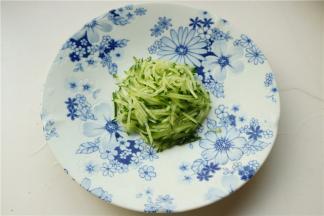 黄瓜切成细丝，放在盘子中央。