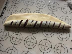 再将面片翻面，划面朝下，由下往上卷起，最后两端收口粘合好，如面团不够粘可涂少许水容易粘合