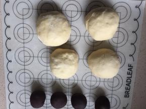 将面团平均分成四份盖上保鲜膜静置松弛20分钟，像包包子一样把豆沙馅包入面团内