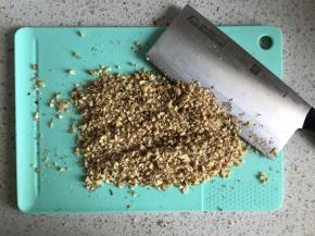 把核桃仁切碎，还有一个简单的办法就是把核桃仁放在保鲜袋里面，用擀面杖擀压