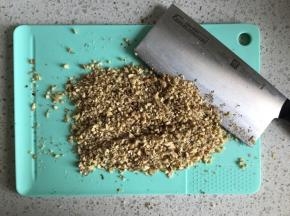把核桃仁切碎，还有一个简单的办法就是把核桃仁放在保鲜袋里面，用擀面杖擀压