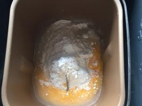 面包机内倒入打散的鸡蛋液和牛奶，再倒入面包材料除了黄油和耐糖酵母以外的全部原料