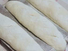 面团发酵40分钟，在表面筛上一些高粉，割些斜口，烤箱预热好后，180度烘烤25分钟。