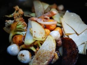 倒入土豆片海鲜丸 加入豆皮 翻炒均匀