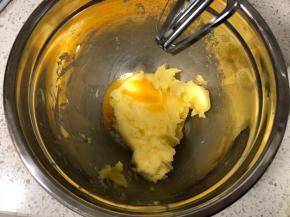 然后先倒入一半的蛋液，用电动打蛋器低速搅打，搅打均匀至黄油和蛋液完全融合