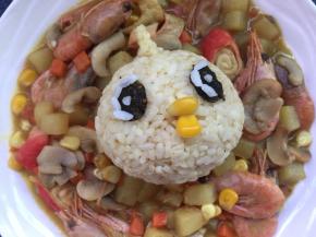 用紫菜剪出小鸡的眼睛，用白米饭点缀一下眼睛，嘴啄用甜玉米粒点缀