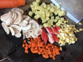 白蘑菇切片，胡萝卜、土豆切粒，蟹味棒切斜刀，甜玉米掰粒