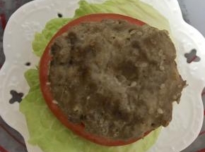 加上牛肉饼，放上芝士片，合上另外半片面包