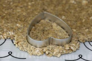 戴上一次性手套或直接用手抓捏均匀，把面团擀成4mm厚的面片，用饼干模盖出饼干胚