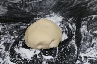 然后在案板上撒粉，把面团放上去