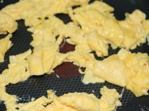 鸡蛋煎至半熟时快速翻炒散～如图，然后捞起备用